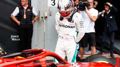 Lewis Hamilton inspekterar en Ferrari-bil.