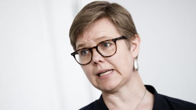 En närbild på Krista Mikkonen med glasögon och stora silverörhängen.