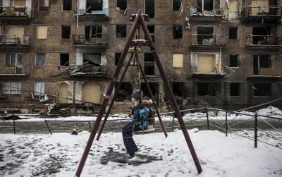 Lapsi keinuu ilmahyökkäyksessä tuhoutuneen asuintalon pihassa Ukrainan Vyšhorodissa. 