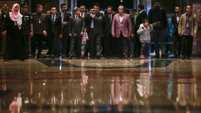 Malaysias utrikesminister Anifah Aman (i röd kavaj) tog emot de nio landsmän som anlände hem till Kuala Lumpur