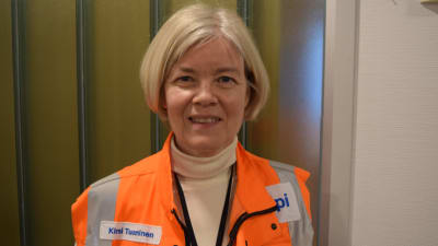En kvinna i orange reflexväst.