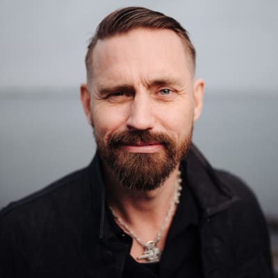 Närbild av Lauri Tähkä som tittar in i kameran. I bakgrunden hav.