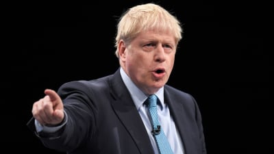 Boris Johnson i kostym, pekar sitt finger åt vänster.