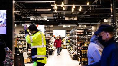 Människor går inne i en Alkoaffär.