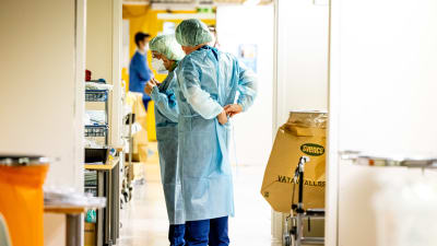 Sjukskötare förbereder sig för att gå in hos en coronapatient.