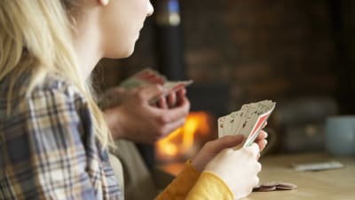 En kvinna som håller i en hög med spelkort i sin hand.