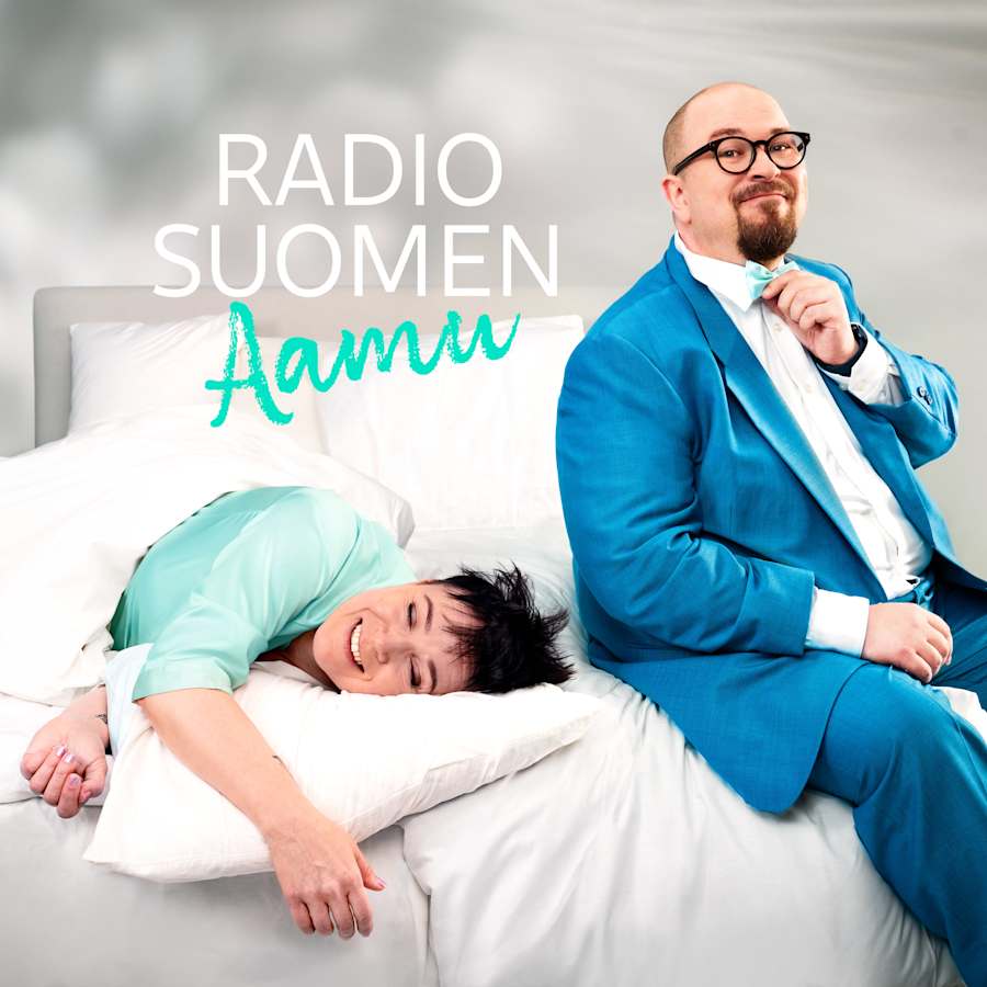 Sanna Pirkkalainen makaa s�ngyll�, p�� tyynyll�, silm�t kiinni ja hymyillen. Matti Yl�nen istuu s�ngyn reunalla siniseen pukuun pukeutuneena, katsoo kameraan hymyillen.