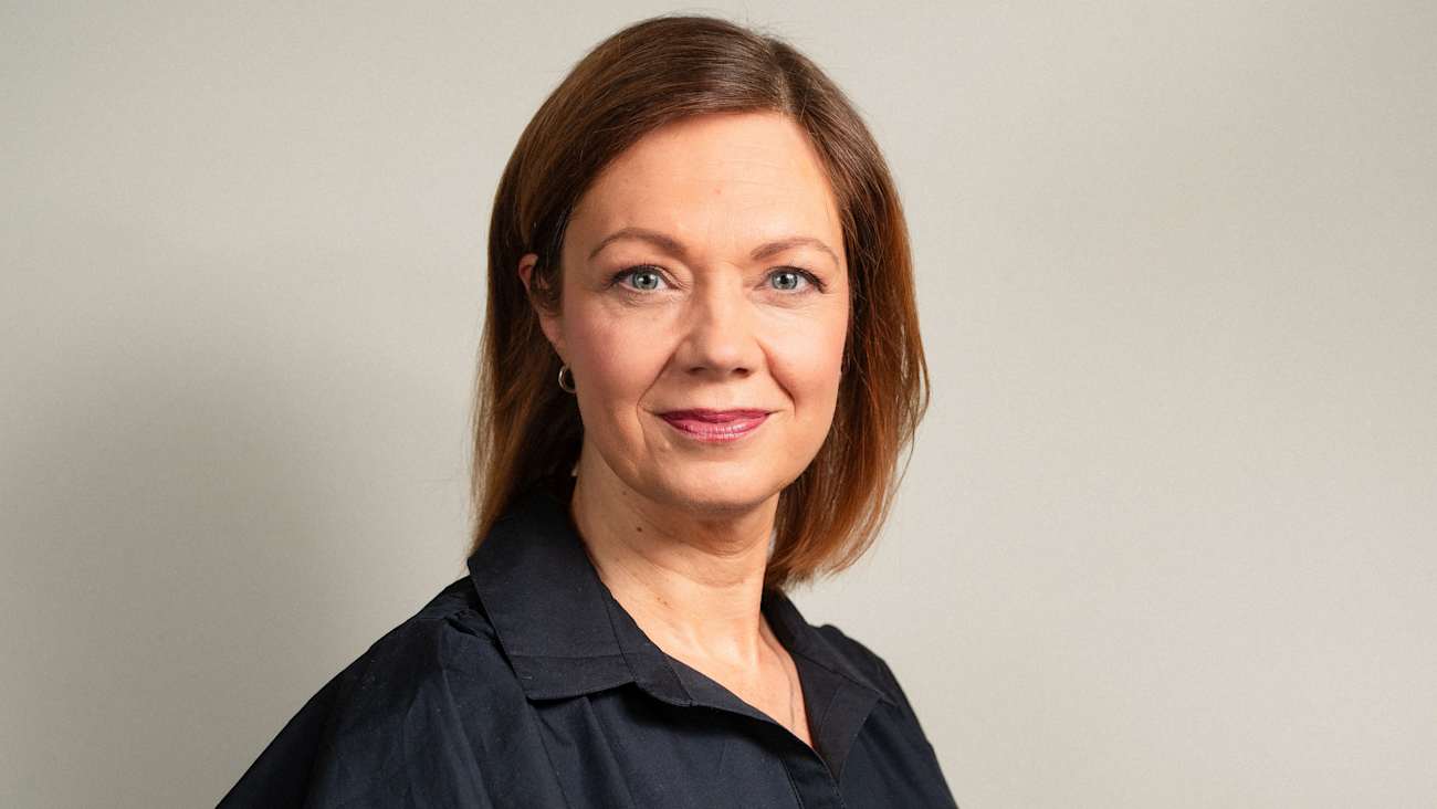 Kuvassa on nainen. H�n on pukeutunut mustaan paitaan ja hymyilee kameralle.