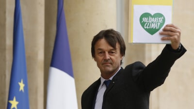 Nicolas Hulot håller upp en skylt med ett grönt hjärta med texten solidaritet för klimatet.