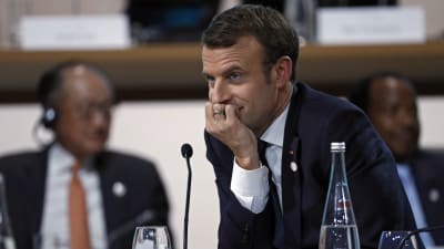Emmanuel Macron lutar huvudet i handen på klimatmötet.