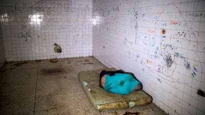 Mentalvårdspatient på en smutsig madrass på ett psykiatriskt sjukhus i Caracas, Venezuela 14.7.2019. Sjukhusen i Venezuela befinner sig i kris till följd av bristen på mediciner och de låga löner som staten betalar personalen.