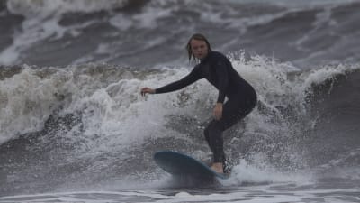 En surfare i Newport, Rhode Island, uttnyttjar de stora vågorna som föregår orkanen Florence.