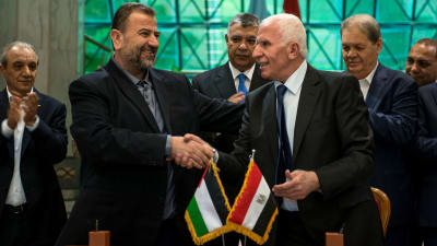 Hamas vice-ledare Saleh al-Aruri skakar hand med Fatahs representant Azam al-Ahmed efter att ha undertecknat gruppernas försoningsavtal efter en 10 år lång konflikt. 