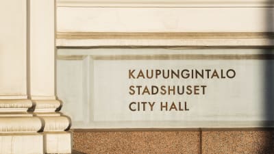 Text på väggen på Helsingfors stadshus där det står Kaupungintalo Stadshuset City Hall.