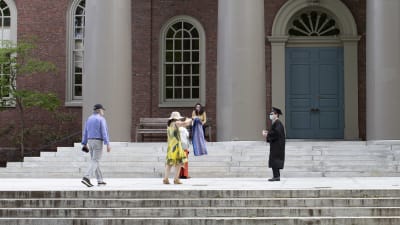 En student vid Harvard firar sin examen med sin familj under strikta coronaåtgärder, med  avstånd och ansiktskydd.