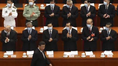 President Xi Jinping promenerar i förgrunden förbi ledamöter i den kinesiska Nationella folkkongressen. Ledamöterna har andningsskydd på sig.