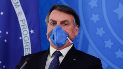 Jair Bolsonaro hade på sig en ansiktsmask åtminstone under en del av sin presskonferens i presidentpalatset den 20 mars. 