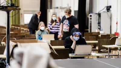 Personer i munskydd under studentskrivningar i Helsingfors i mars 2021.