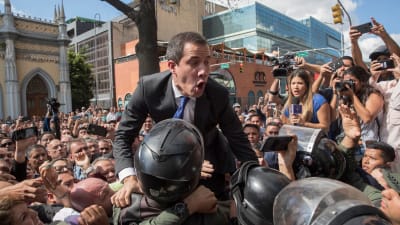 Den venezuelanska oppositionsledaren Juan Guaidó pressar sig förbi säkerhetsstyrkor den 7 januari 2020 för att kunna ta sig till parlamentet.