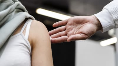 En ung kvinna får plåster på armen efter vaccination