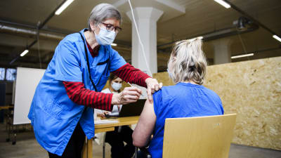 En person som jobbar inom hälsovården får coronavaccin.