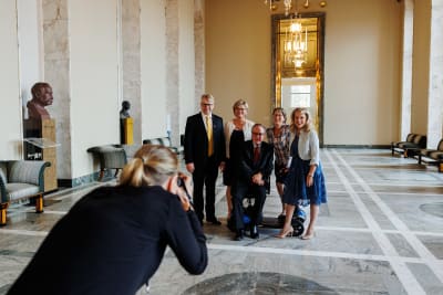 Kristdemokraternas riksdagsgrupp poserar framför fotograf i riksdagen.