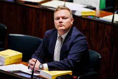 Antti Kurvinen sittande på sin plats i riksdagens plenisal. 