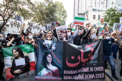 Människor som protesterar i Iran mot islamska regimen. De håller i många bilder på Mahsa Amini, vars död startade protesterna i landet.