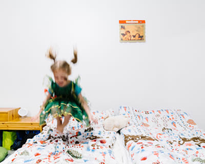 En ukrainsk flicka som flytt till Finland hoppar i en säng.