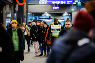 En ordningsvakt i ett folkmyller på Dickursby järnvägsstation.