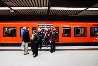 Personer stiger på ett metrotåg vid Helsingfors järnvägsstation.