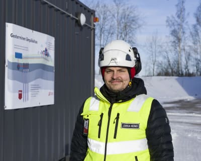 Jukka Heino, utvecklingschef på Vanda Energi. En man i vinterjacka, reflexväst och skyddhjälm i ett snöigt landskap. 
