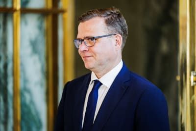 En man i blå kostym småler.
