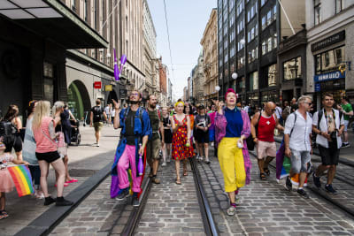 Färgglatt klädda människor går i prideparaden i Helsingfors.