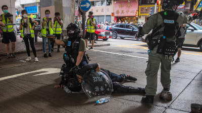 Kravallpolis griper en man i samband med demonstrationer mot en ny nationell säkerhetslag i Hongkong 1.7.2020
