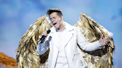 roko sjunger för kroatien i esc 2019 och har en vit dräkt med stora fjädervingar i guld på ryggen