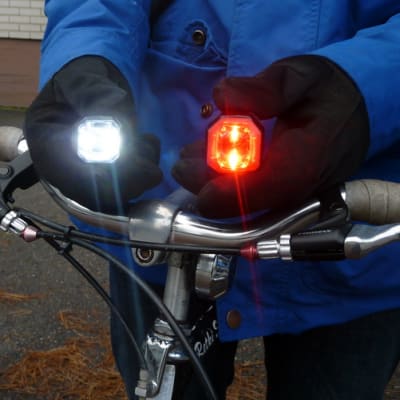 Pyöräilijä esittelee pyöränsä valoja.