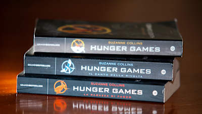 Tre Hunger Games-böcker på hög på ett träbord.