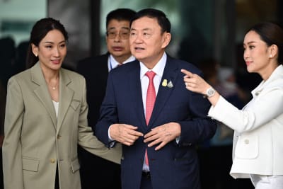 Thailands förra premiärminister Thaksin Shinawatra hälsar på sina anhängare 