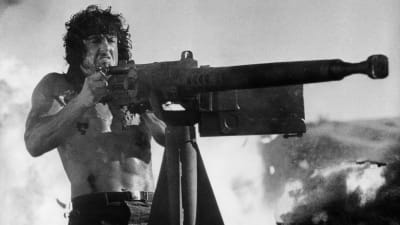 Sylvester Stallone som Rambo skjuter med tungt automatvapen.