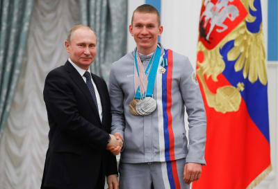 Vladimir Putin och Alexander Bolsjunov skakar hand och ser nöjda ut.