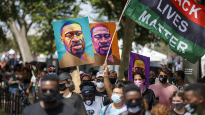 Mielenosoittajat Yhdysvalloissa kantavat poliisiväkivallan seurauksena kuollutta Goerge Floydia esittäviä värikkäitä kylttejä.