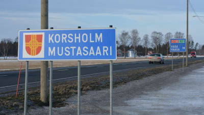 Skylt med texten Korsholm i förgrunden och skylt med texten Vasa i bakgrunden.