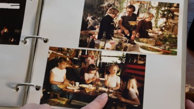 Ett fotoalbum med bilder. Det är fest i båtskjulet. Tove Jansson tar mat och Kim Gustafsson sitter vid barnbordet.