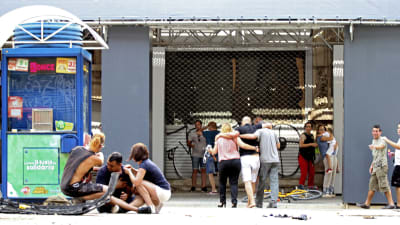 Skadade personer sitter på gatan på La Rambla i centrala Barcelona. 