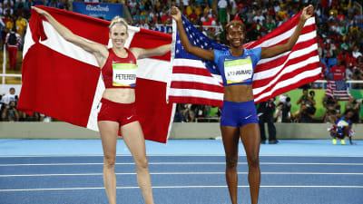 En danska och en amerikanska håller upp sina respektive länders flaggor efter häcklopp.