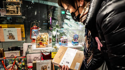 Nainen katselemassa lahjoja joulukaupassa.