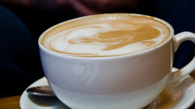 Kaffekopp med mjölkkaffe i