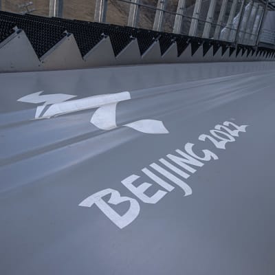 Nedre delen av en hoppbacke med Peking-OS logo i mitten.