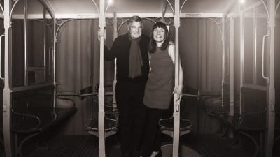 En svartvit bild på Claes Anderson tillsammans med Julia Korkman. De står bredvid varandra och med armarna över varandras axlar.